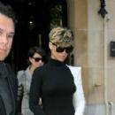 Rihanna wearing black dress with left arm white sleeve