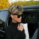 Rihanna wearing black dress and left arm white sleeve