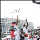 DJ Clue drives on two defenders during Big Tigger's weekend Celebrity Game