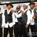 All six members of New Edition pose backstage for a picture after their performance