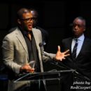 Producer Tyler Perry speaks after receiving his award at the 2011 Triumph Awards while Rev. Al Sharpton looks on