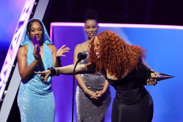 SZA Struggles To Navigate Skin-Tight Dress At 2025 AMAs