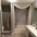 Long sheer white curtain scarf above bathtub