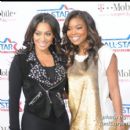 La La and Actress Gabrielle Union pose together for pictures on the magenta carpet before the game