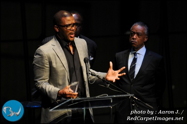 Producer Tyler Perry speaks after receiving his award at the 2011 Triumph Awards while Rev. Al Sharpton looks on